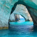 Hermosa vista sobre Blue Caves arcos de roca de turismo en barco con los turistas en el agua azul del Mar Jónico dentro de la cueva azul. Isla Zakynthos Grecia vacaciones viajes viajes.