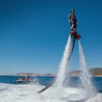 Flyboarding and seariding on the Sea near the mountain island. Water summer extreme sports.