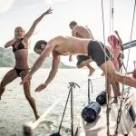 I fidanzati si divertono in barca a vela e si tuffano in acqua