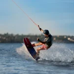 Teenage boy wakeboarding on river. Extreme water sport