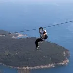 Man going down on rope above Adriatic sea. Adventure attraction near Dubrovnik. Croatia.
