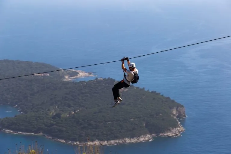 Man going down on rope above Adriatic sea. Adventure attraction near Dubrovnik. Croatia.